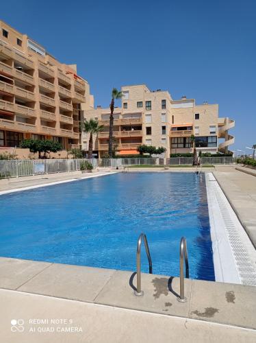 une piscine vide avec des bâtiments en arrière-plan dans l'établissement Appartement vue mer, au Barcarès