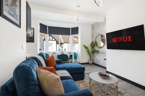 a living room with a blue couch and a table at 30 percent off! Elegant Yorkshire Abode - Great Location - Sleeps 19 in Castleford