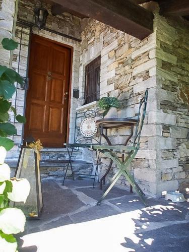 a table and chairs in front of a building with a door at Casa ai Ghiri in Cannero Riviera