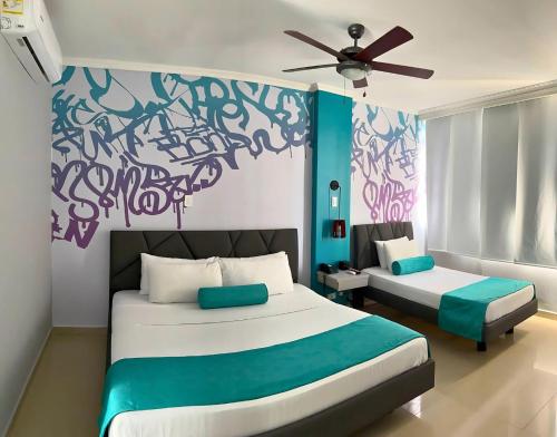 a bedroom with two beds and a ceiling fan at GIO hotel Tama Cartagena in Cartagena de Indias