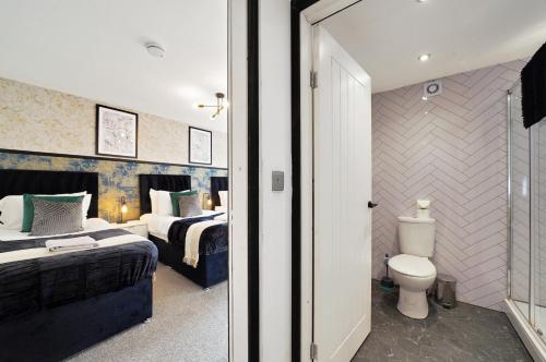 a bedroom with a bed and a toilet in it at 30 percent off! Elegant Yorkshire Abode - Great Location - Sleeps 19 in Castleford