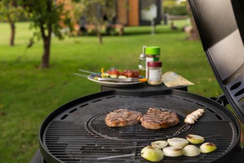 a grill with some meat and vegetables on it at Applewood Cabin 2 by Tiny Away in Christchurch