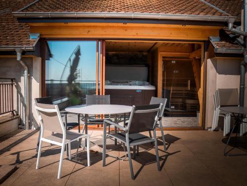 un patio avec une table et des chaises sur un balcon dans l'établissement Feuille de vigne, à Gueberschwihr