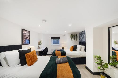 a bedroom with two beds and a living room at 30 percent off! Elegant Yorkshire Abode - Great Location - Sleeps 19 in Castleford
