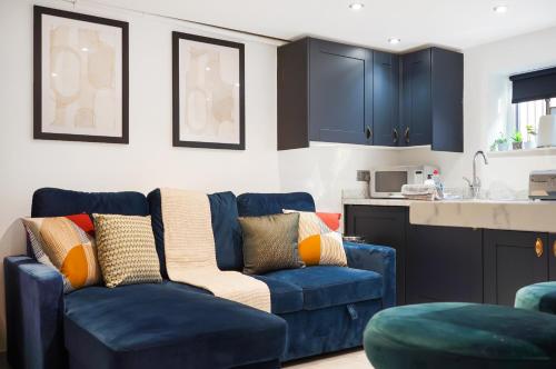 a living room with a blue couch and a kitchen at 30 percent off! Elegant Yorkshire Abode - Great Location - Sleeps 19 in Castleford