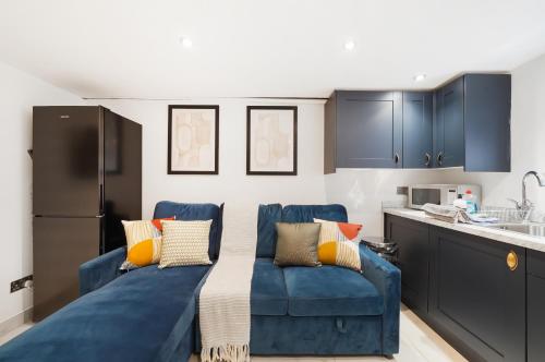 a living room with a blue couch in a kitchen at 30 percent off! Elegant Yorkshire Abode - Great Location - Sleeps 19 in Castleford