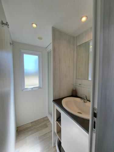 a bathroom with a sink and a window at chalet 2 au coeur du maquis in Bonifacio