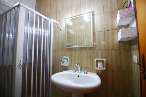 a bathroom with a sink and a shower with a mirror at HOMESICILY - Total relaxing in a private property in Floridia