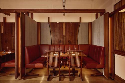 a dining room with red chairs and a table at The Connaught, Maybourne in London