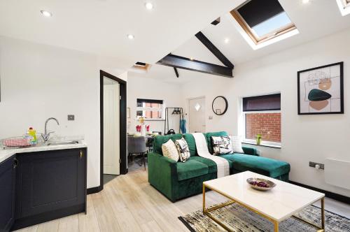 a living room with a green couch and a table at 30 percent off! Elegant Yorkshire Abode - Great Location - Sleeps 19 in Castleford