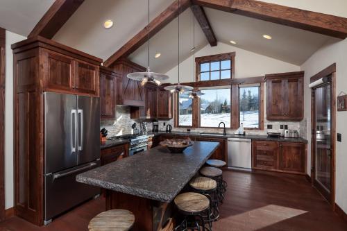 a kitchen with wooden cabinets and a black refrigerator at Lodge at Whitefish Lake in Whitefish