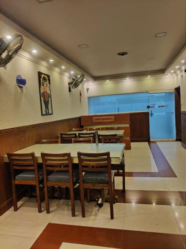 a restaurant with a table and chairs and a screen at LlBRA REGENCY in Guruvāyūr