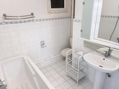 une salle de bain blanche avec un lavabo et des toilettes dans l'établissement Situation et vue mer exceptionnelle 62L, à Cannes