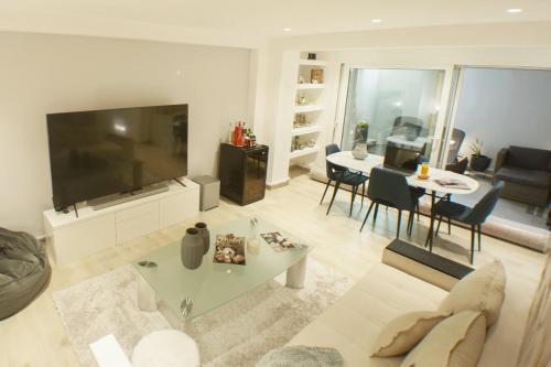 a living room with a large television and a table at Luxury 2 storey 2bedroom condo with Private Jacuzzi & patio - Athens in Athens