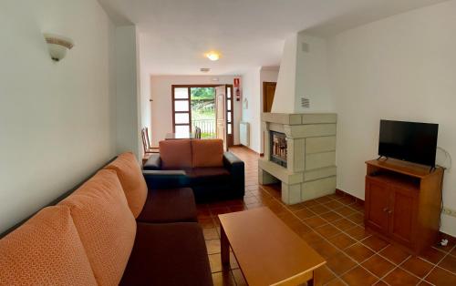 a living room with a couch and a television at Apartamentos Puente La Molina in Carreña de Cabrales 