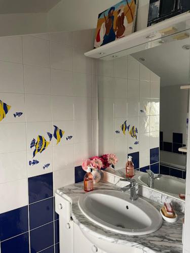 une salle de bain avec un lavabo et un miroir dans l'établissement Chez Pierre et Caroline, aux Herbiers