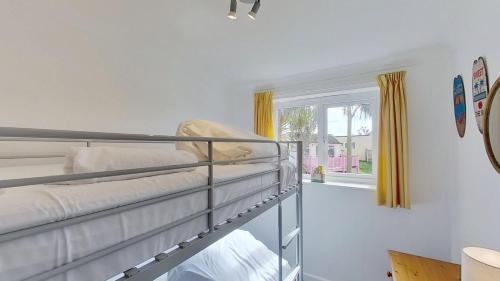 a bedroom with two bunk beds and a window at F11 Roslyn, Riviere Towans in Hayle