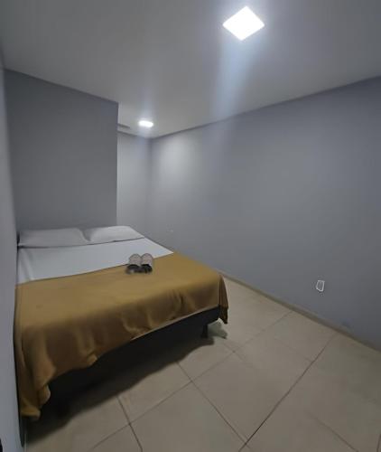 une chambre avec un lit avec deux chaussures dessus dans l'établissement Lindo apart. Terreo recreio dos bandeirantes no Rio de janeiro, à Rio de Janeiro