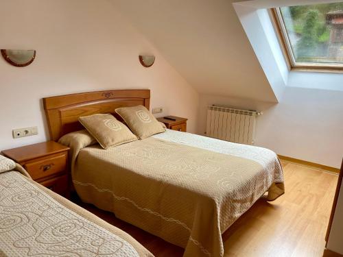 a bedroom with two beds and a window at Apartamentos Puente La Molina in Carreña de Cabrales 