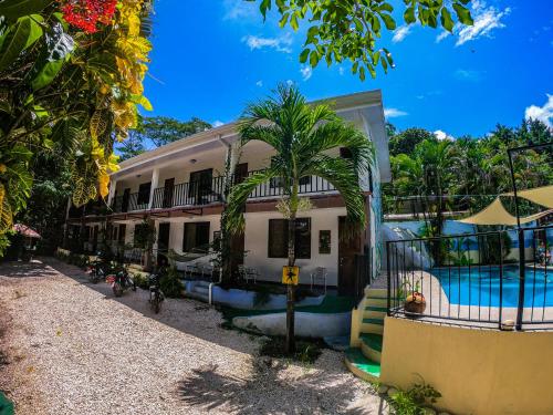 a building with a swimming pool in front of it at La Posada - Hostel in Santa Teresa Beach