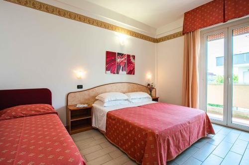 a hotel room with a bed and a window at Hotel San Giacomo in Cesenatico