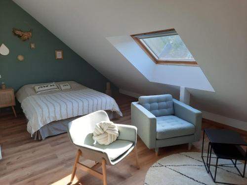 une chambre mansardée avec un lit et une chaise dans l'établissement studio proche plage avec jacuzzi, à Camiers