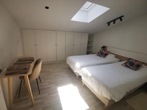 une chambre avec deux lits et un bureau et une fenêtre dans l'établissement Toulouse, Bourse nice and comfortable family apartment, à Toulouse
