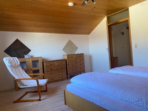 1 dormitorio con cama, silla y vestidor en Ferienwohnung Münnerstadt, en Münnerstadt