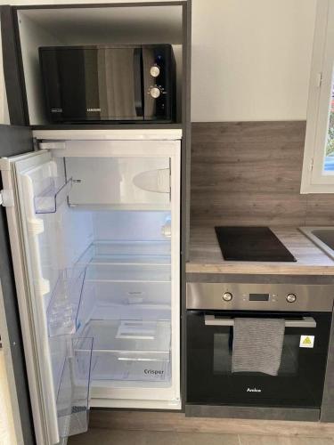 - un réfrigérateur avec une porte ouverte dans la cuisine dans l'établissement Les Villas Gîtes de Vertrieu, à Vertrieu