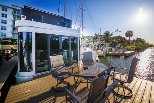 a deck with a table and chairs on a boat at Unique Houseboat Rental in Merritt Island