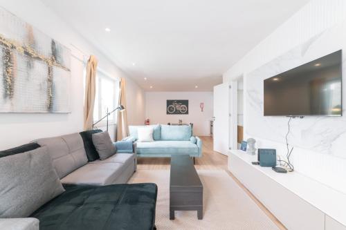 a living room with a couch and a tv at Duplex Apartment near Belém in Lisbon
