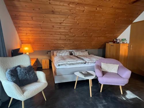 a bedroom with a bed and two chairs at Stolzing-Apart in Bayreuth