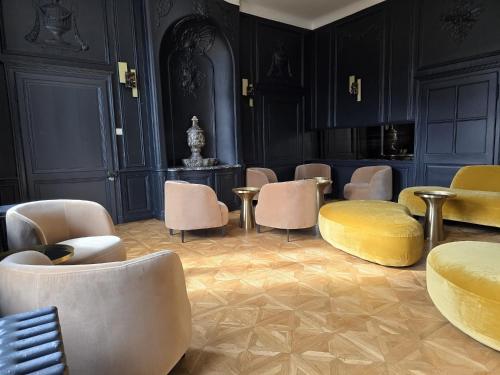 a waiting area with chairs and tables in a room at Logis - Hostellerie Saint-Louis & Restaurant Pauze in Bollezeele