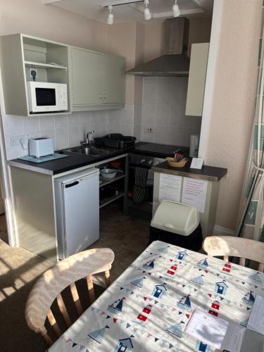 a small kitchen with a table and a counter top at Carnock in Tenby