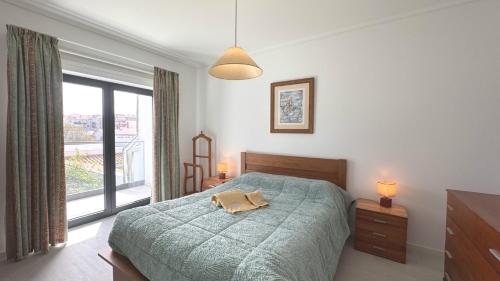 una camera da letto con un letto e una grande finestra di Casa da Praia, piscina a sal, aquecida e coberta -Praia da Barra a Praia da Barra