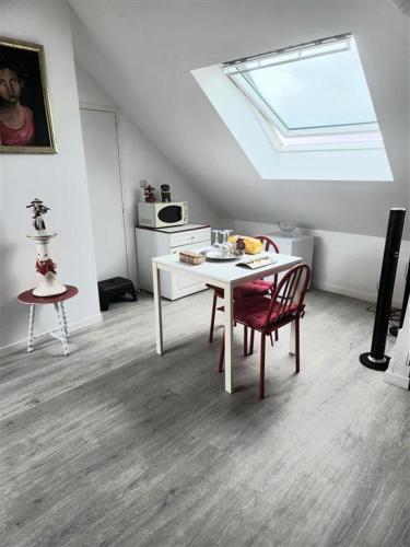 Cette chambre dispose d'une table et de chaises blanches ainsi que d'une fenêtre. dans l'établissement audouard, à Saint-Aubin-sur-Mer