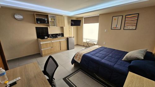 a bedroom with a bed and a table and a kitchen at ACEQUIA SUITES WHITE & BLACK para 1 a 2 personas ESPECIALISTAS EN CORTAS, MEDIANAS Y LARGAS ESTANCIAS en IZCALLI TEPOTZOTLAN perfectas para Familias, Turistas, Contratistas, Estudiantes, Empresas y Ejecutivos a sólo 5 min Izcalli in Cuautitlán Izcalli