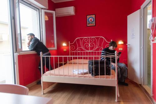 a man and a child in a small room with a bed at Sunflower Beach Backpacker Hostel & Bar in Rimini