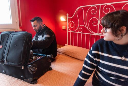 a man is standing next to a girl with a suitcase at Sunflower Beach Backpacker Hostel & Bar in Rimini