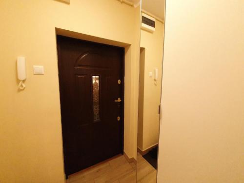 a hallway with a black door in a room at Apartament Słoneczny in Wałbrzych