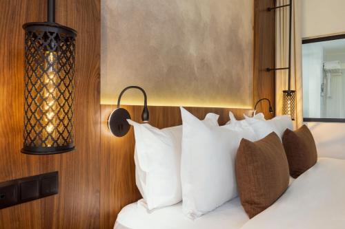 a bedroom with a bed with white pillows at Le Meridien N'fis in Marrakech