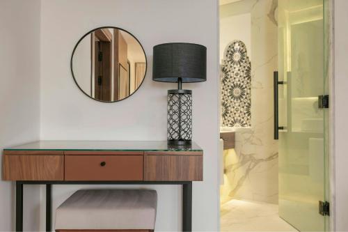 a dressing table with a lamp and a mirror at Le Meridien N'fis in Marrakech