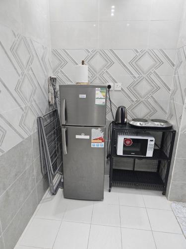 a refrigerator in a room with a tile wall at Welcome Two 5km far from Masjid Nabawi in Al Madinah