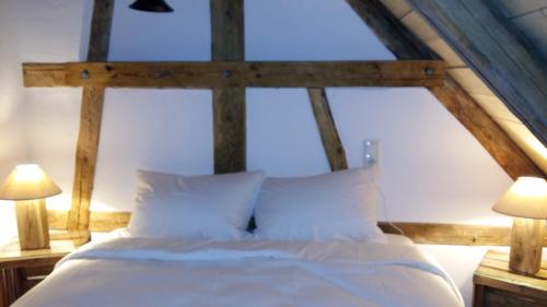 a bedroom with a large white bed with two lamps at Pension & Café Schlupfwinkel in Salem