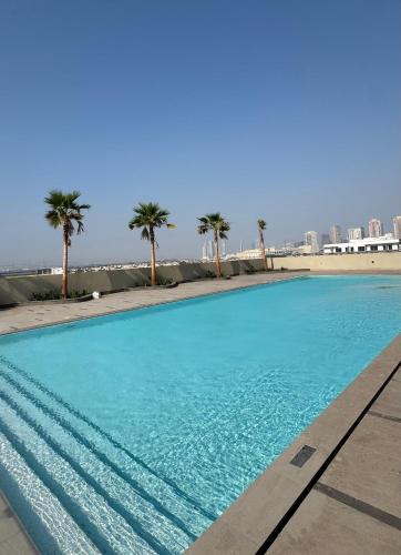 a large swimming pool with palm trees in the background at The Community Jumeirah Village in Dubai
