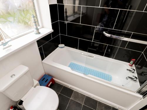 a bathroom with a white toilet and a bath tub at Caedmon's Rest in Whitby
