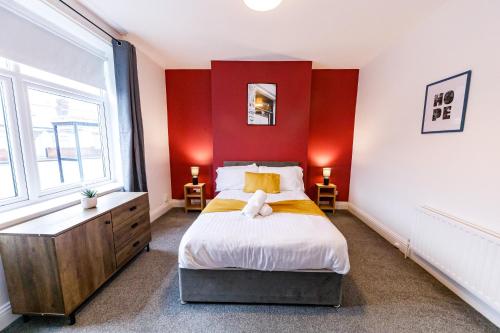 a bedroom with a large bed with red walls at 2 Bedroom Home-Free Parking-Perfect for Contractors in Pallion