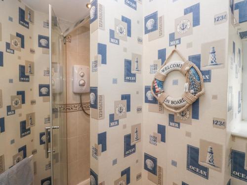 a bathroom with a shower with a wreath on the wall at Gorse Bank in Broughton in Furness