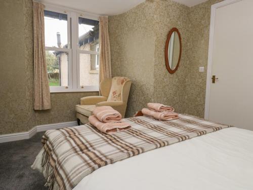 a bedroom with a bed with pink towels on it at Gorse Bank in Broughton in Furness