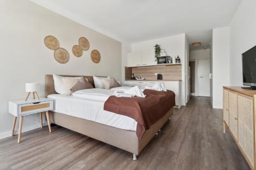 a bedroom with a large bed and a television at Beachside Grömitz - 21 Apartments, Pool & Sauna direkt am Meer in Grömitz